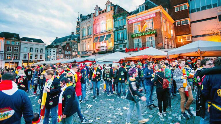 Carnavalsvierders op een plein met versierde gevels